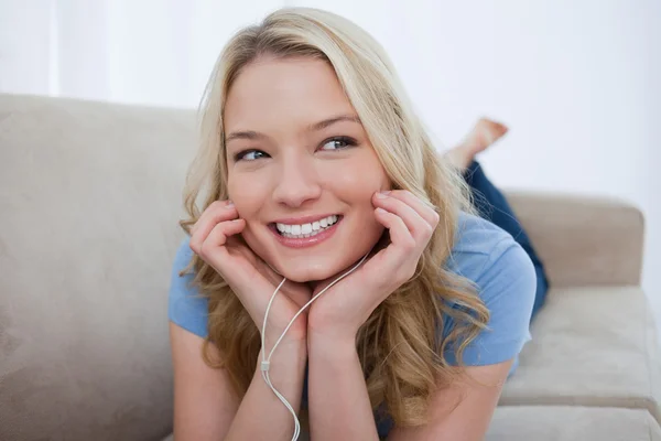 Una donna sorridente sta ascoltando musica con le cuffie — Foto Stock