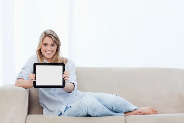 Bir tablet onun önünde tutan bir gülümseyen kadın — Stok fotoğraf