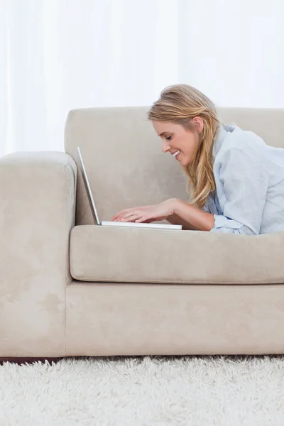 Uma visão lateral de uma mulher digitando em um laptop — Fotografia de Stock