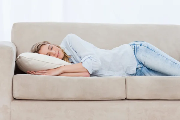 Una donna addormentata è sdraiata su un divano — Foto Stock