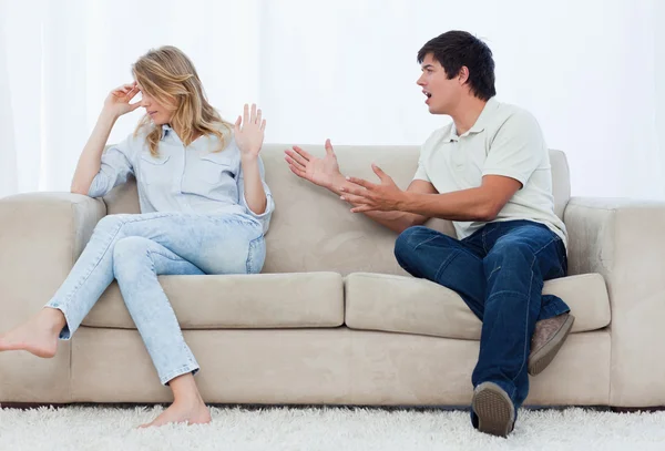A man is having an argument with his girlfriend while sitting on — Stock Photo, Image