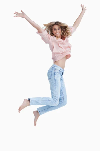 Mulher pulando com os braços levantados — Fotografia de Stock