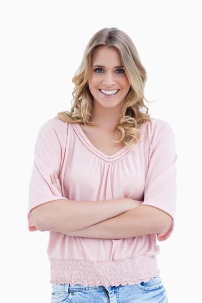 En leende kvinna som står med armarna vikta — Stockfoto