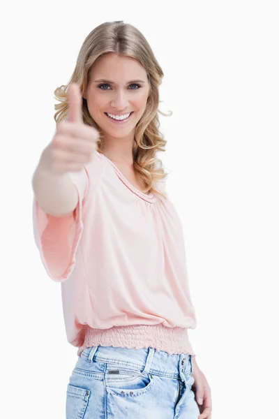 Eine blonde Frau mit erhobenem Daumen lächelt in die Kamera — Stockfoto