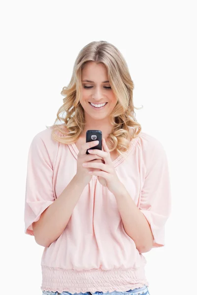 Улыбающаяся женщина смотрит на свой мобильный телефон — стоковое фото