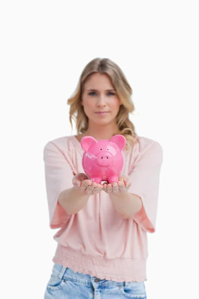 Vrouw met een piggy bank in de Palm van haar hand — Stockfoto