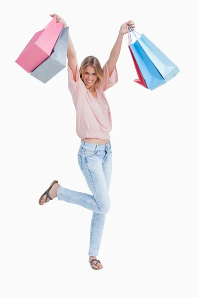 Eine Frau steht und hält Einkaufstüten hoch — Stockfoto