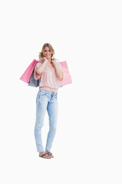 Uma mulher está carregando sacos de compras sobre o ombro — Fotografia de Stock