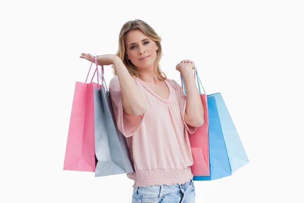 Una mujer cargando bolsas de compras sobre su hombro — Foto de Stock