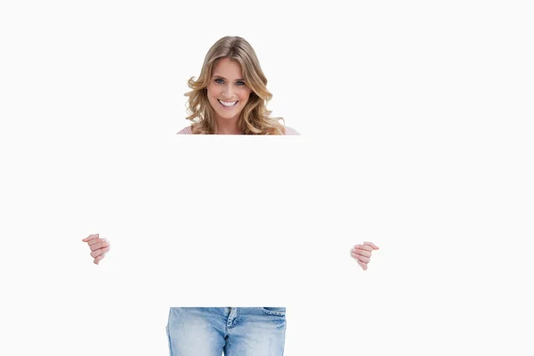 En kvinna som ler hålla en vit skylt — Stockfoto