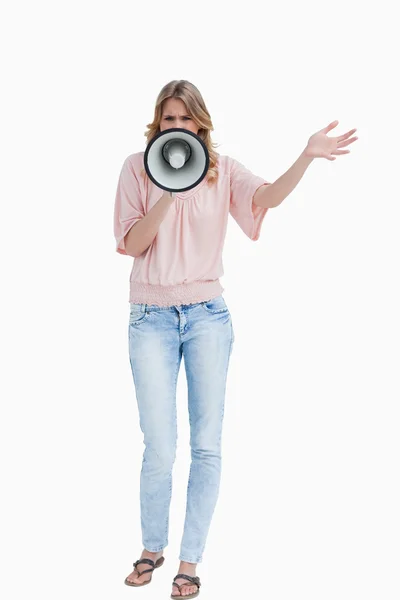 Young woman standing upright while using a megaphone — Stock Photo, Image