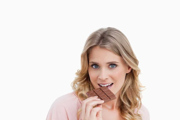 Junge blonde Frau isst Schokolade — Stockfoto