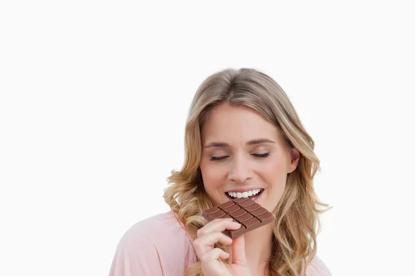 Jonge vrouw een heerlijke vrede van chocolade eten — Stockfoto
