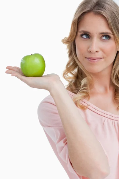 Uśmiechnięta młoda kobieta trzyma jabłko — Zdjęcie stockowe