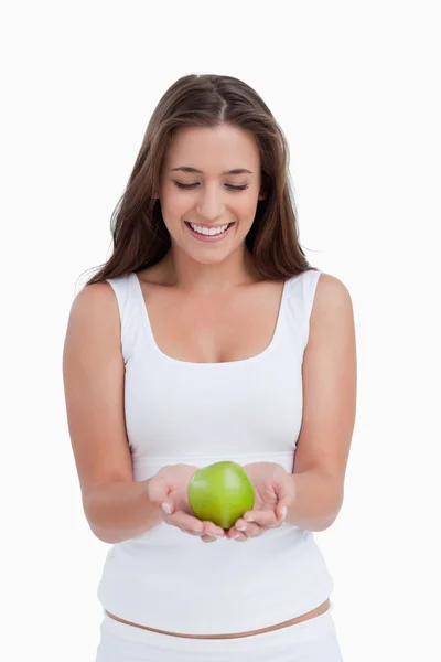 Sorrindo morena mulher segurando uma bela maçã verde — Fotografia de Stock