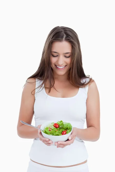 Lachende brunette vrouw met een kom van salade — Stockfoto