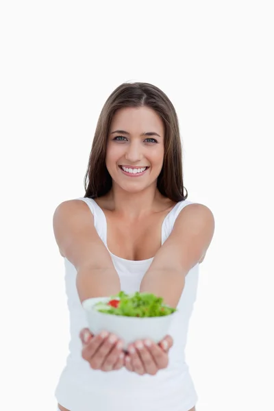 Χαμογελώντας νέα γυναίκα που κρατά μια σαλάτα — Φωτογραφία Αρχείου
