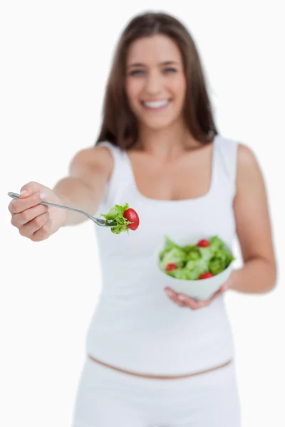 Fork with salad being held by a young woman — Stock Photo, Image