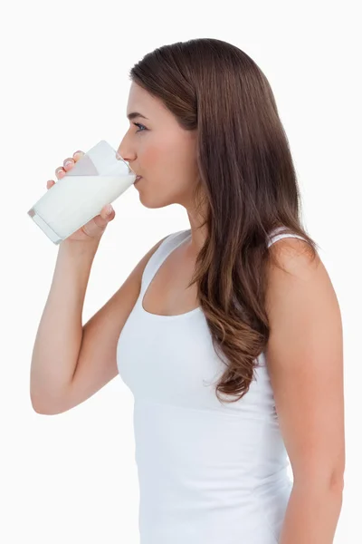Genç bir kadın süt içiyor yan görünüm — Stok fotoğraf
