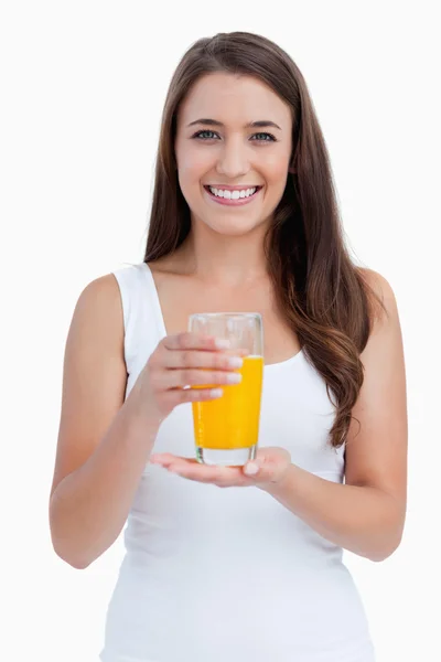 Улыбающаяся женщина держит стакан апельсинового сока — стоковое фото
