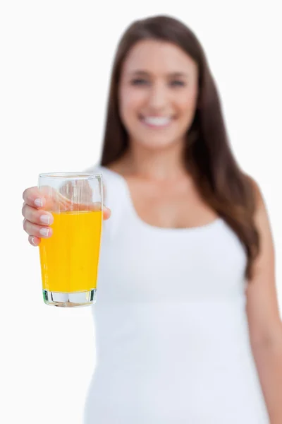 Copo de suco de laranja sendo realizada por uma jovem mulher — Fotografia de Stock