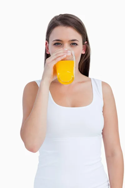 Mujer joven bebiendo un zumo de naranja — Foto de Stock