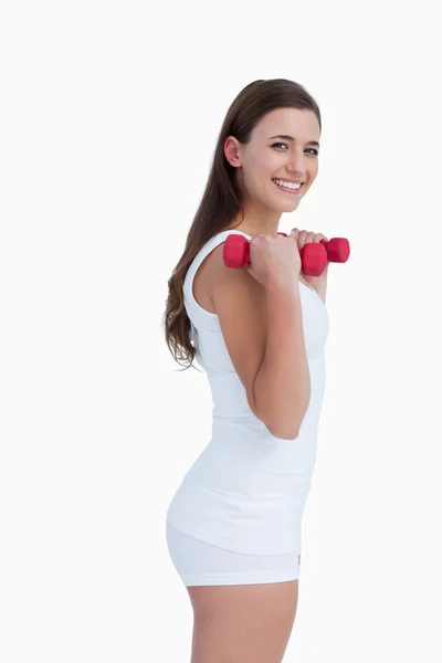 Side view of a young brunette holding dumbbells — Stock Photo, Image