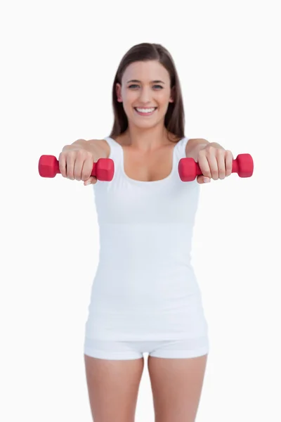 Red dumbbells being held by a young woman — Stock Photo, Image
