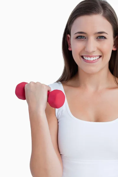 Smiling woman looking at the camera while holding a weight — Stock Photo, Image