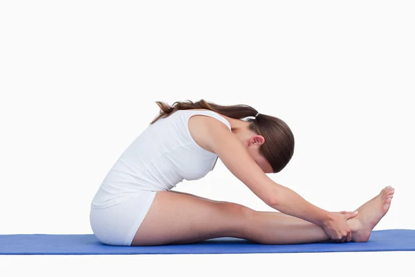 Yoga minderinde oturan genç kadın. — Stok fotoğraf