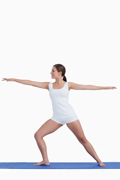 Lachende vrouw praktizerende yoga op een mat — Stockfoto