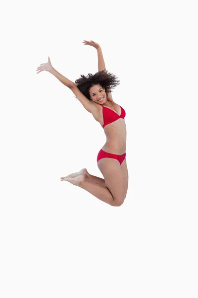 Вид сбоку на прыгающую молодую женщину — стоковое фото