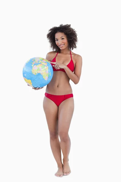 Lachende vrouw wijzen een strandbal globe — Stockfoto