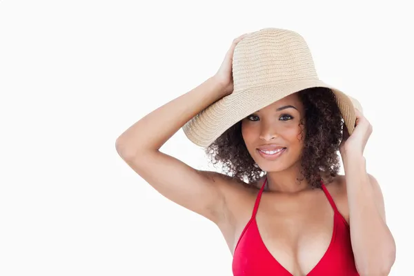 Mujer sonriente sosteniendo su sombrero de paja — Foto de Stock