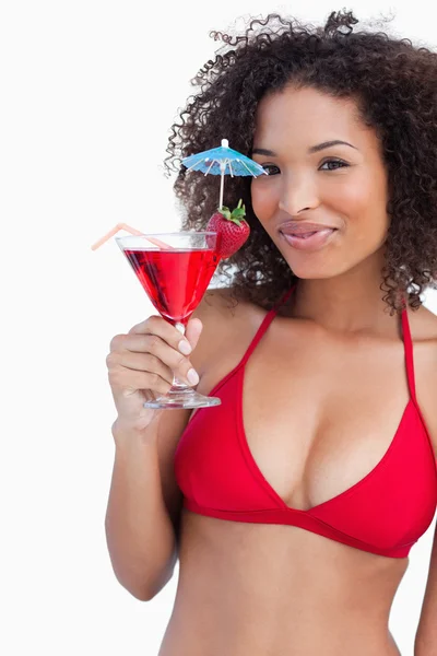 Junge Frau blickt in die Kamera, während sie einen Cocktail hält — Stockfoto