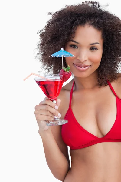 Young brunette holding a red cocktail — Stock Photo, Image