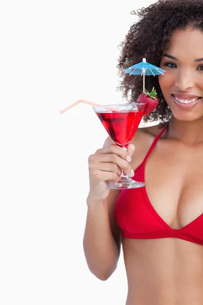 Smiling brunette looking at the camera while holding a cocktail — Stock Photo, Image