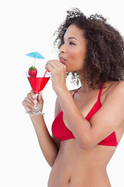 Young brunette looking away while sipping a cocktail — Stock Photo, Image