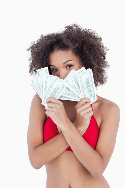 Brunette woman hiding her face behind two fans of notes — Stock Photo, Image