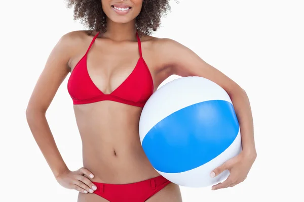 Usměvavá brunetka žena držící míč beach — Stock fotografie