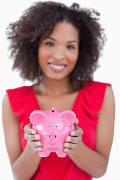Prasátko bank drží bruneta žena — Stock fotografie