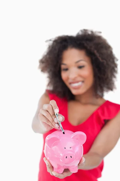 Różowy piggy bank otrzymujący banknoty — Zdjęcie stockowe