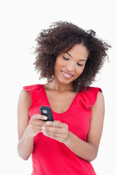 Smiling young brunette woman holding a mobile phone — Stock Photo, Image