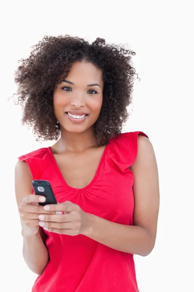 Uśmiechający się młoda kobieta, trzymając jej telefon komórkowy — Zdjęcie stockowe