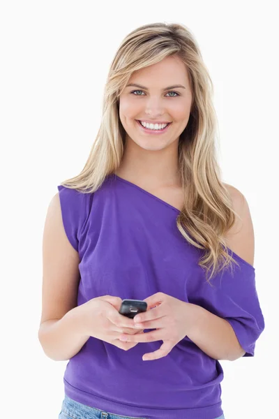 Smiling blonde woman looking at the camera while holding her mob — Stock Photo, Image