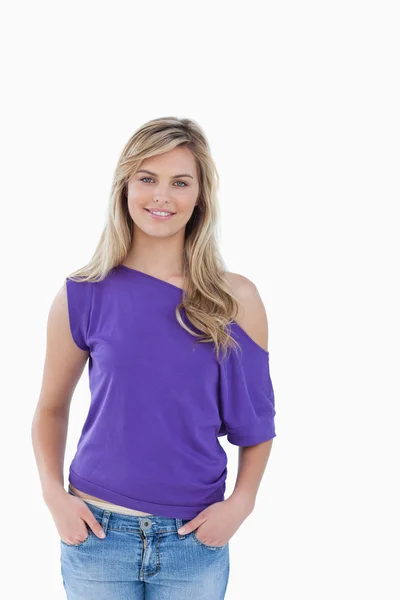Smiling blonde woman placing her hands in her pockets — Stock Photo, Image
