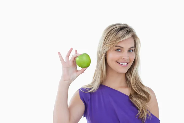 Lachende blonde vrouw die houdt van een groene appel — Stockfoto