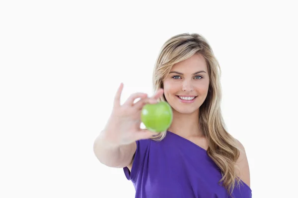 微笑着的金发女郎，举行一个美味的绿色苹果 — 图库照片