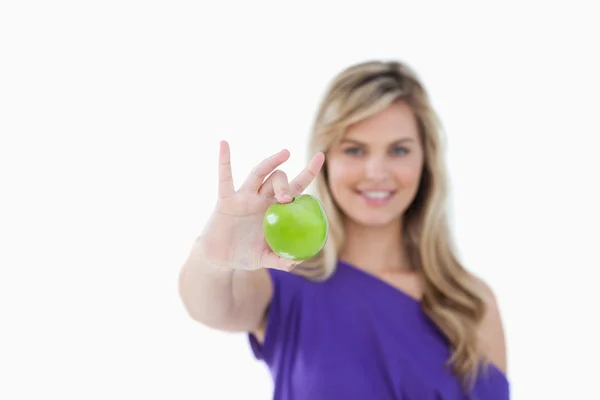 Grønt eple som holdes av en blond kvinne – stockfoto