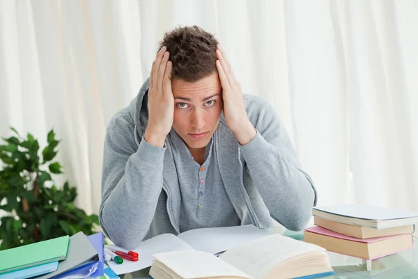 Retrato de un estudiante angustiado haciendo sus deberes — Foto de Stock